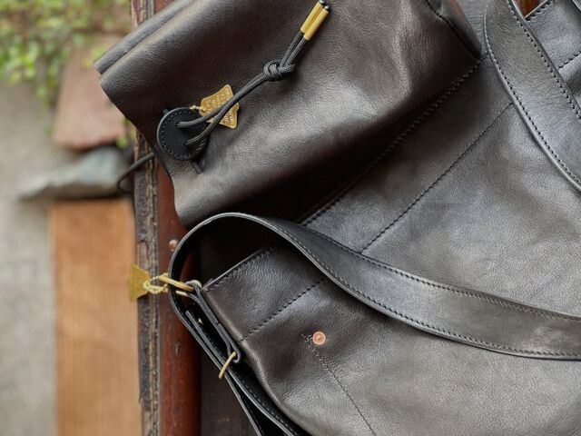 新入荷。牛ブラック。
ポルトガルのタンナーによる馬革のように仕上げられた牛革ブラックでホーボーSとボンショルダーを製作頂きました。ヌバックを使い込んだような艶と軽さがあって素敵。洗練された雰囲気で黒には黒にしかないカッコ良さがありますな。オススメ。

・benlly's & job 
hobo tote s  牛黒　
size  W25.0cm × D12.5cmXH32.5cm 
price ¥24200

bon sac shoulder 牛黒　
size  W14.0cm × D14.0cmXH23.0 
price ¥13200
Made in Kanazawa Japan